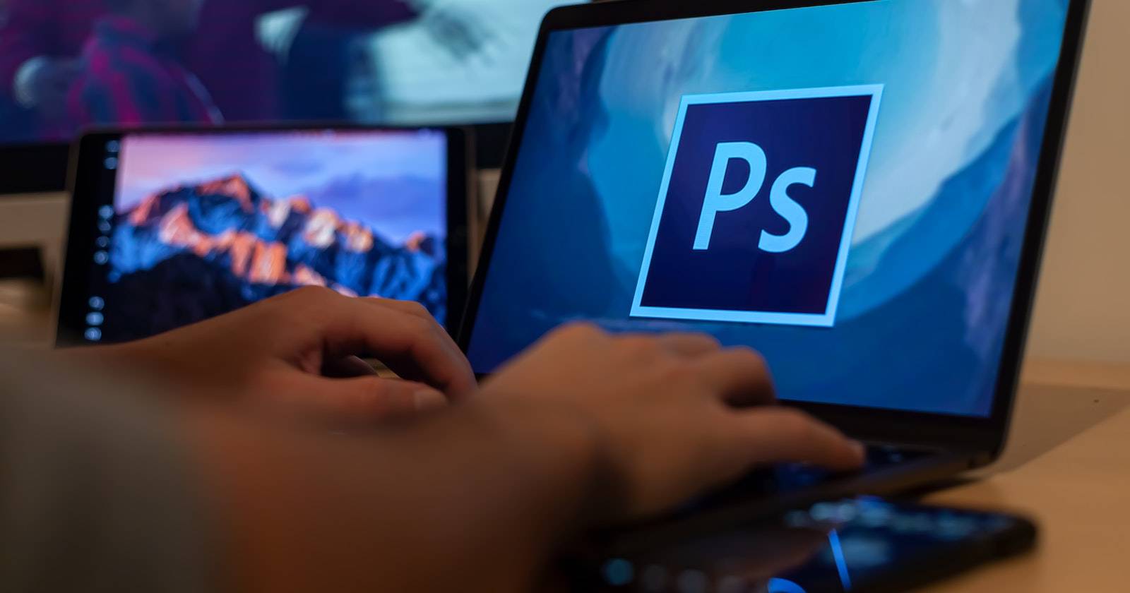 Человек использует Adobe Photoshop на ноутбуке с Windows