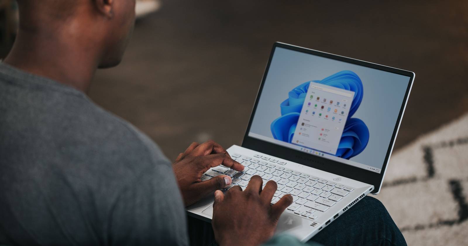 Мужчина за ноутбуком с Windows 11