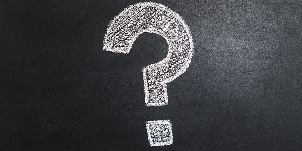 Крупный план вопросительного знака на нейтральном фоне