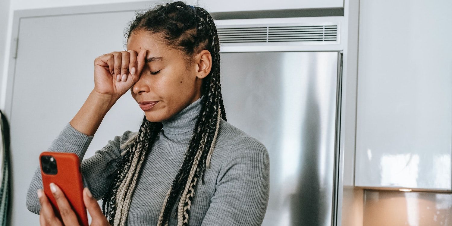 девушка грустная смотрит в телефон