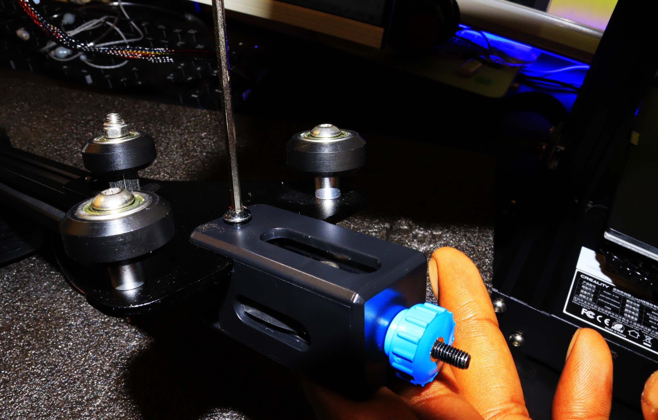 A hand tightening the plastic thumb nut