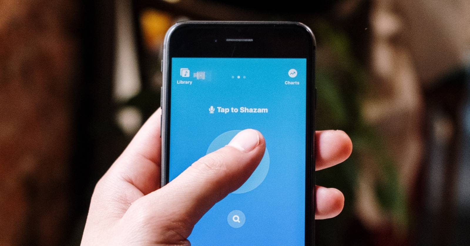 Человек использует Shazam на смартфоне