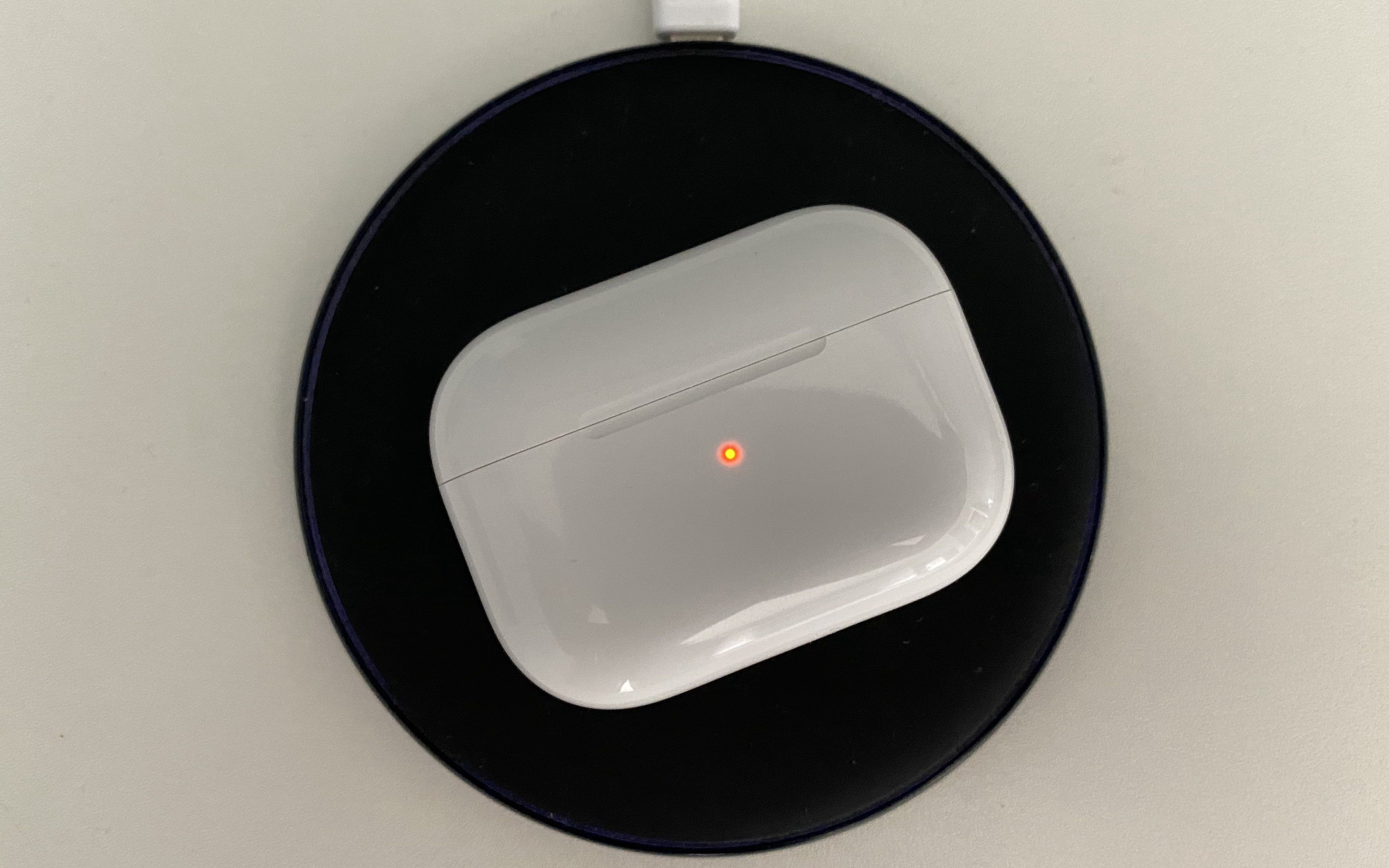 AirPods Pro sitting on a wireless charger and charging.