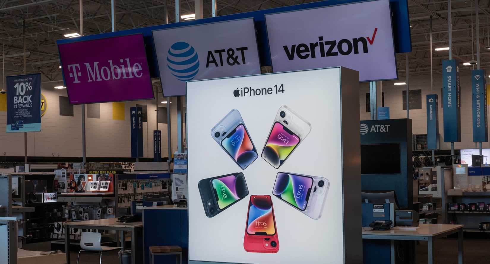 Дисплей iPhone 14 в магазине Best Buy с рекламой операторов T-Mobile, Verizon и AT&T