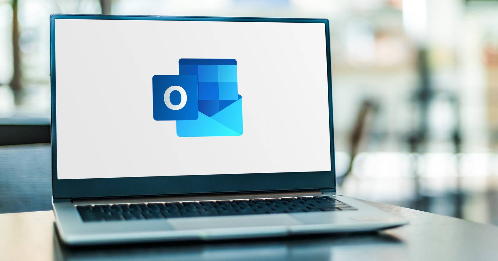 Ноутбук с логотипом Microsoft Outlook на экране