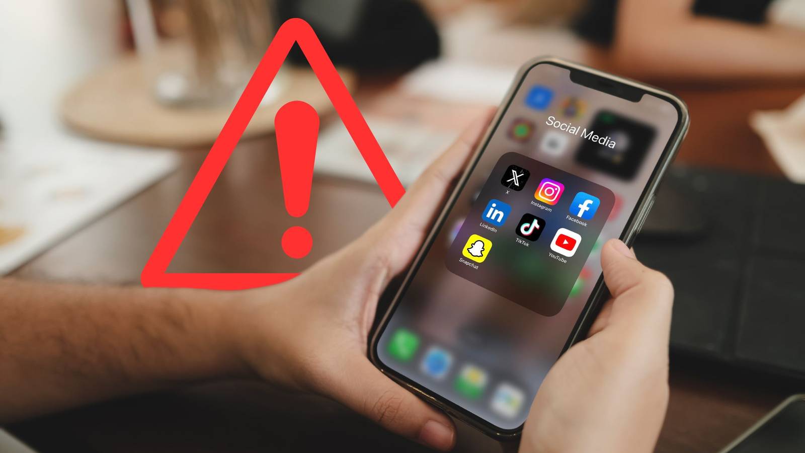 приложения социальных сетей на экране смартфона с иконкой предупреждения