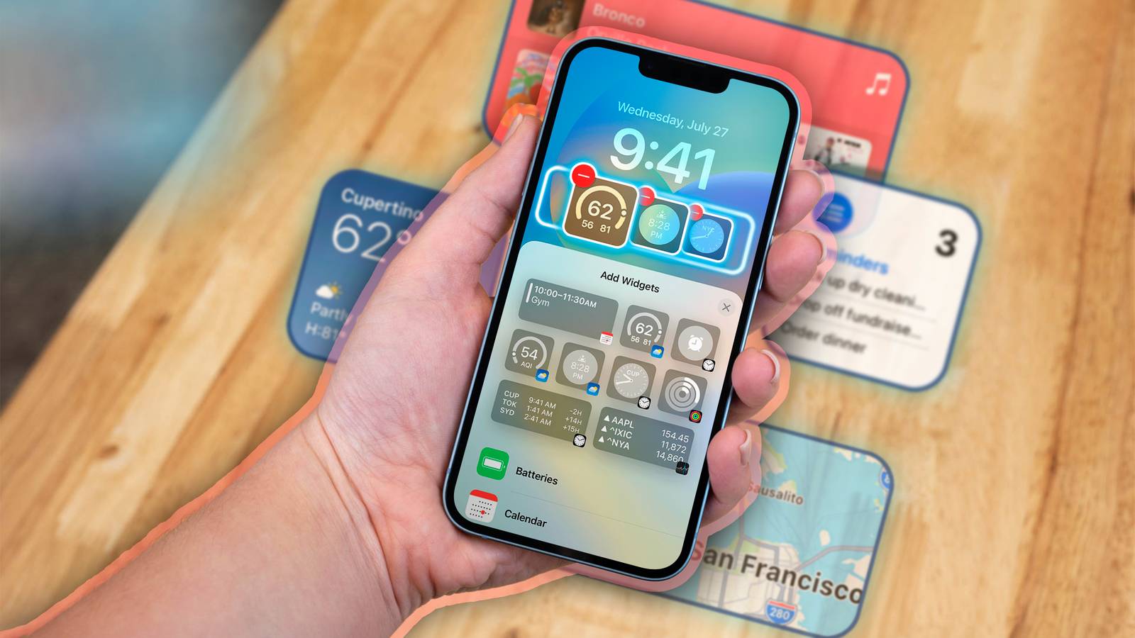 Una mano che tiene un iPhone con vari widget sullo schermo.