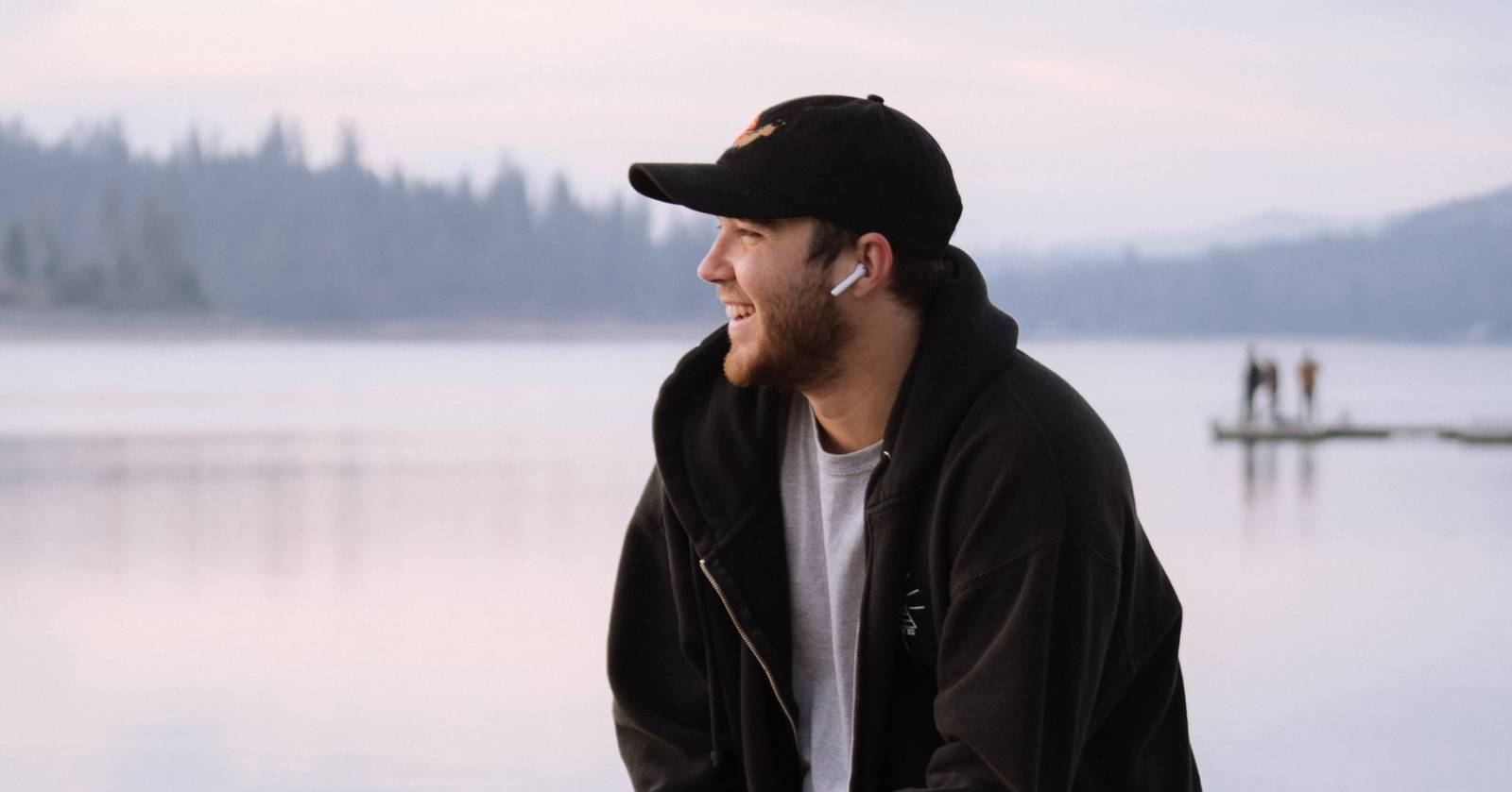 Мужчина в наушниках AirPods, использующий голосовые функции телефона