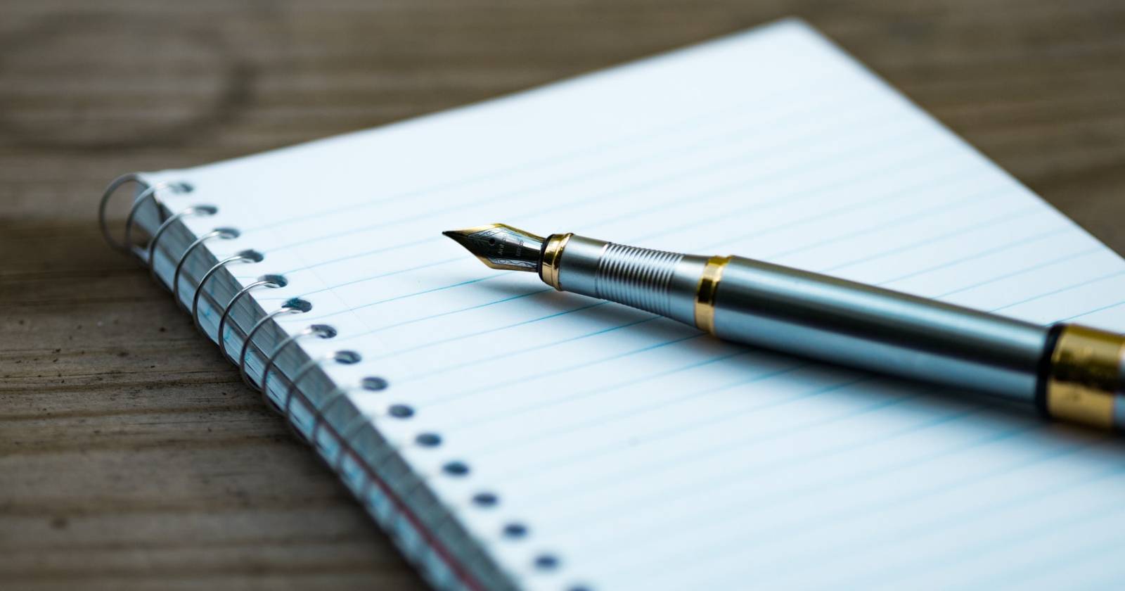 Перьевая ручка на чистом блокноте