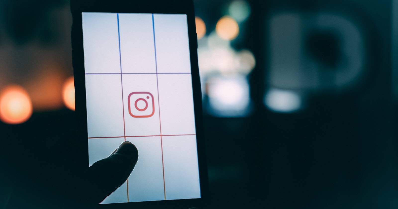 человек держит телефон с логотипом Instagram
