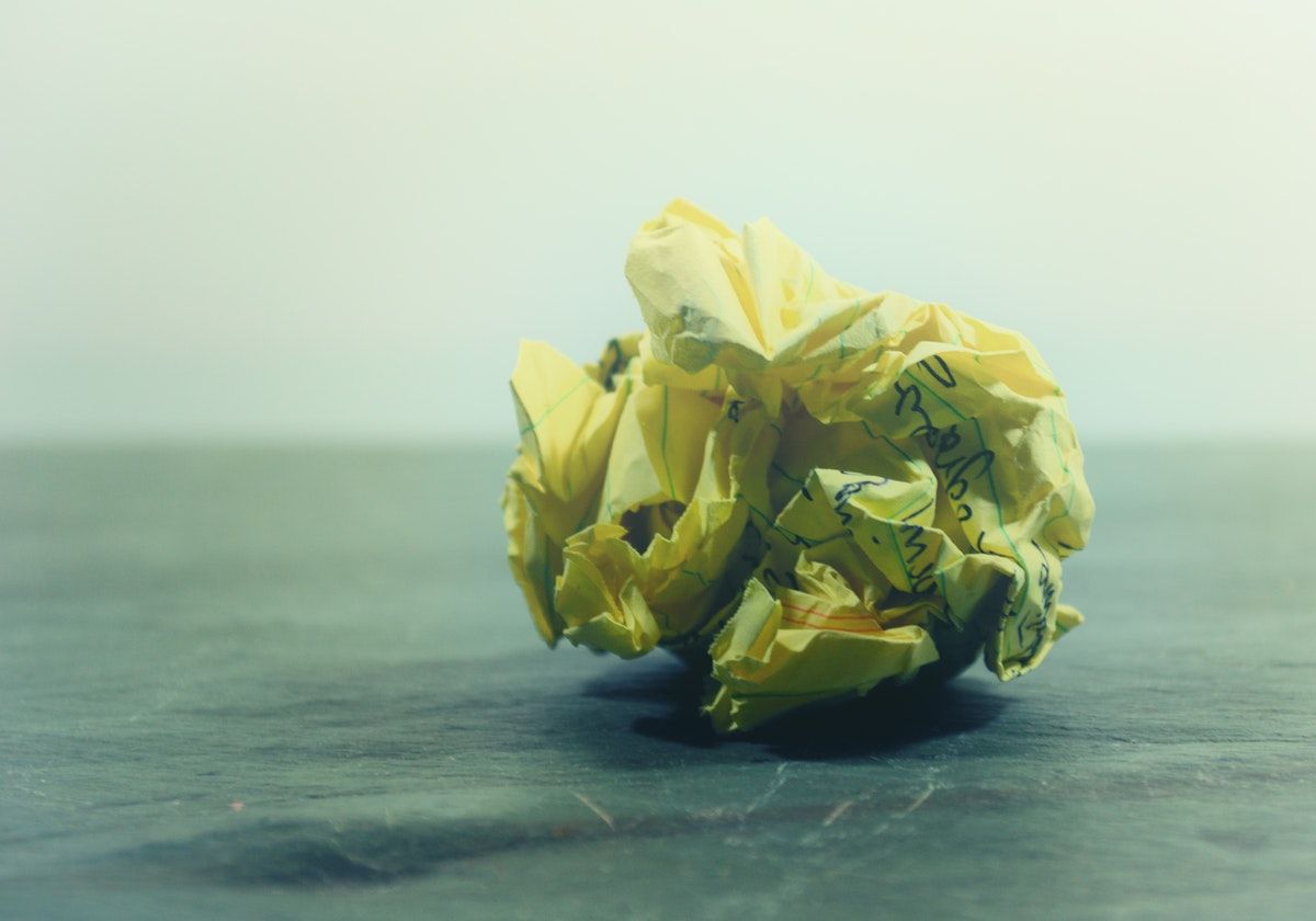 Скомканный желтый лист бумаги со списком книг