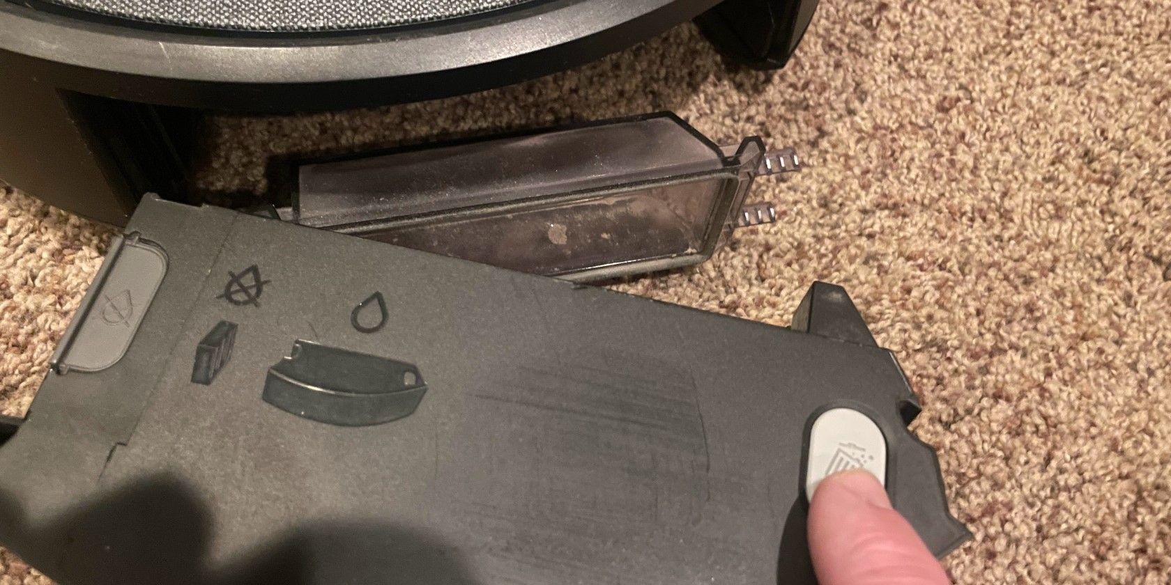 Нажмите серую кнопку, чтобы открыть контейнер Roomba