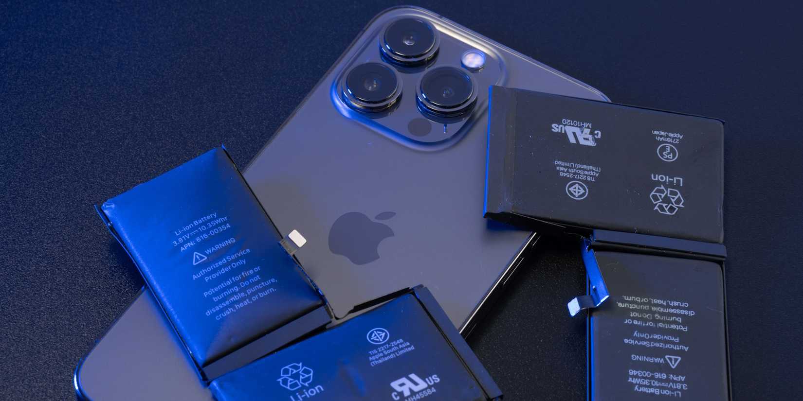 iPhone 14 Pro Max на столе с литий‑ионными батареями сверху