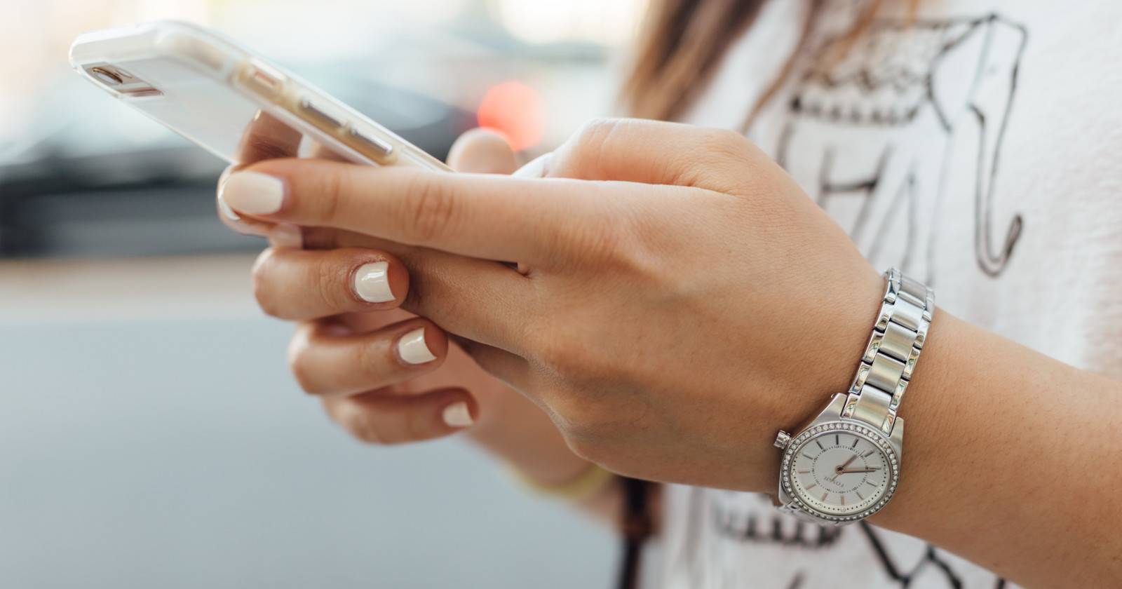 Человек использует iPhone на улице