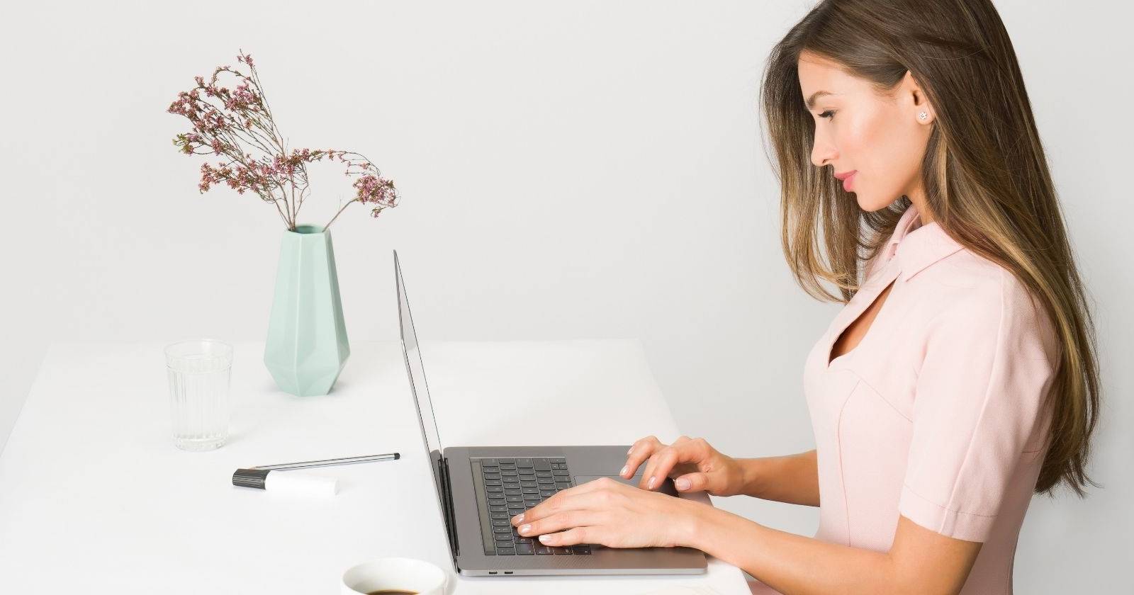 Женщина за компьютером, пишущая статью