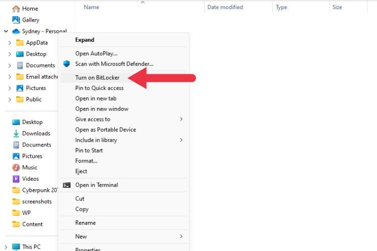 Красная стрелка указывает на пункт «Включить BitLocker» в контекстном меню диска в Проводнике Windows