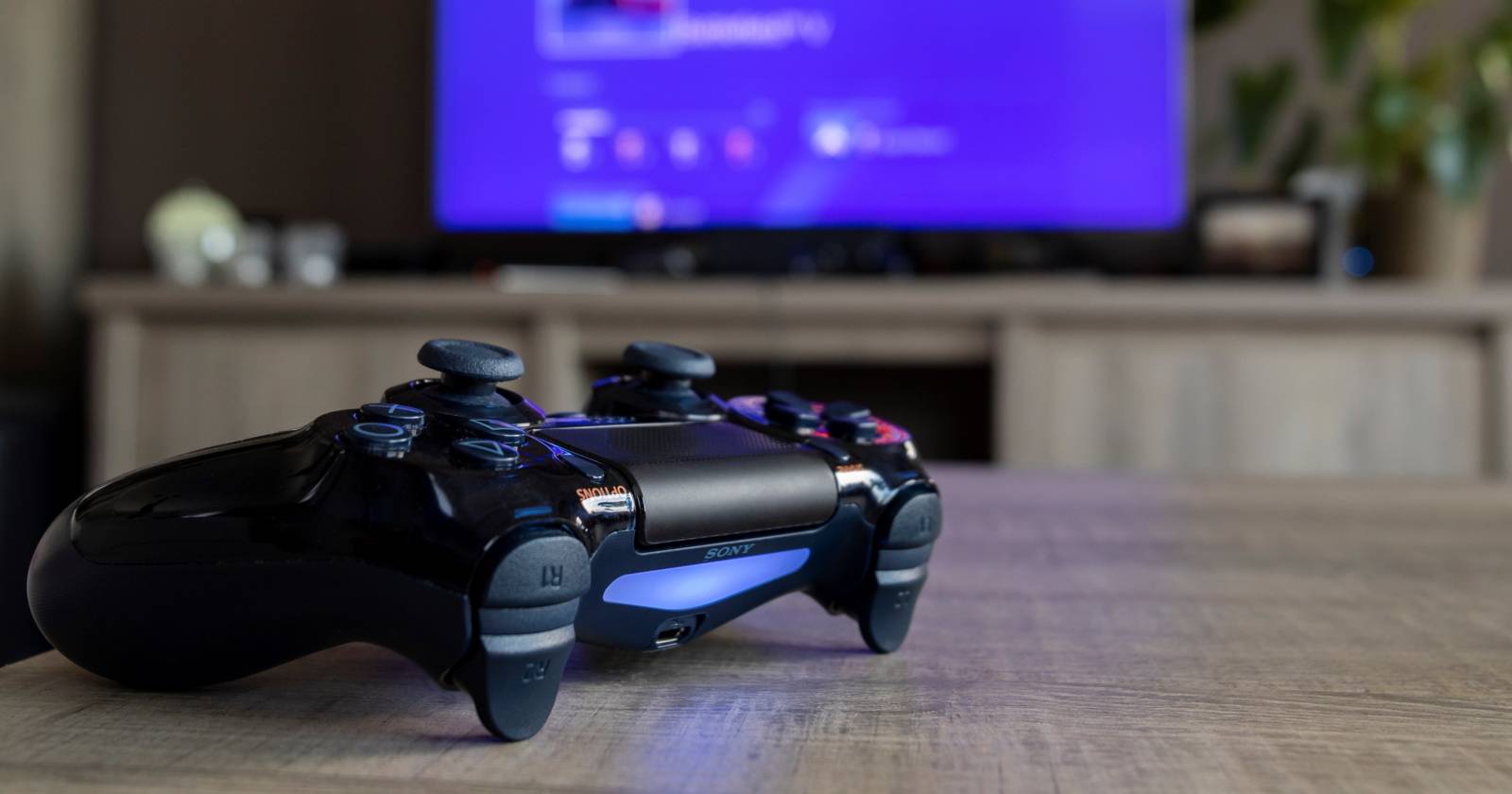 Игровой контроллер DualShock 4 на столе перед телевизором
