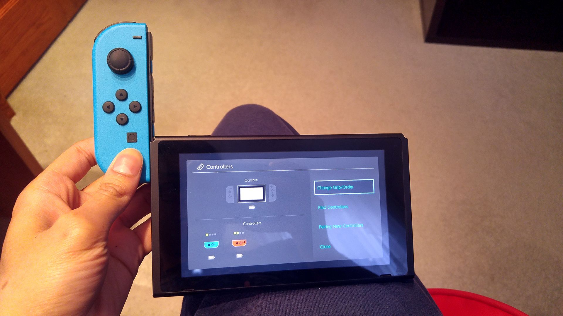 Вставка левого Joy‑Con в левую направляющую Nintendo Switch.