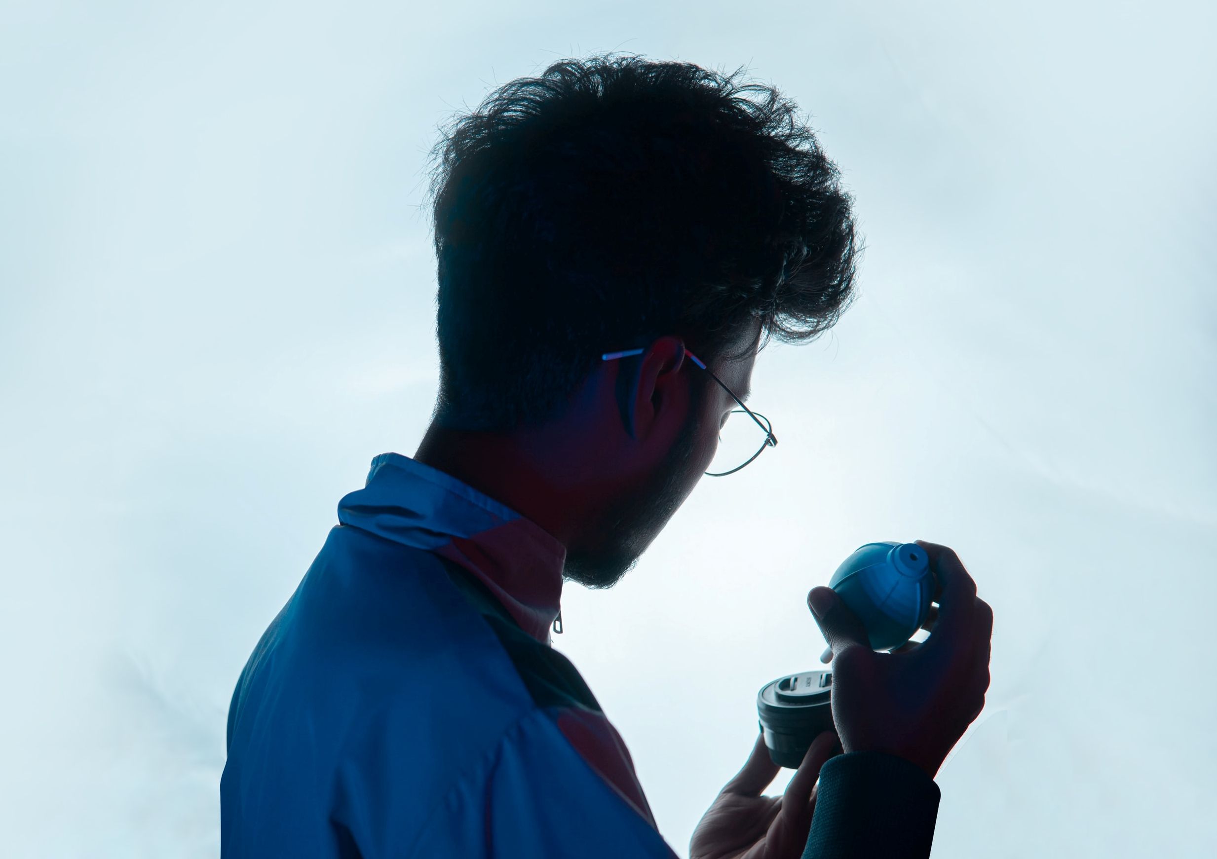 Человек удаляет пыль с объектива при помощи груши.