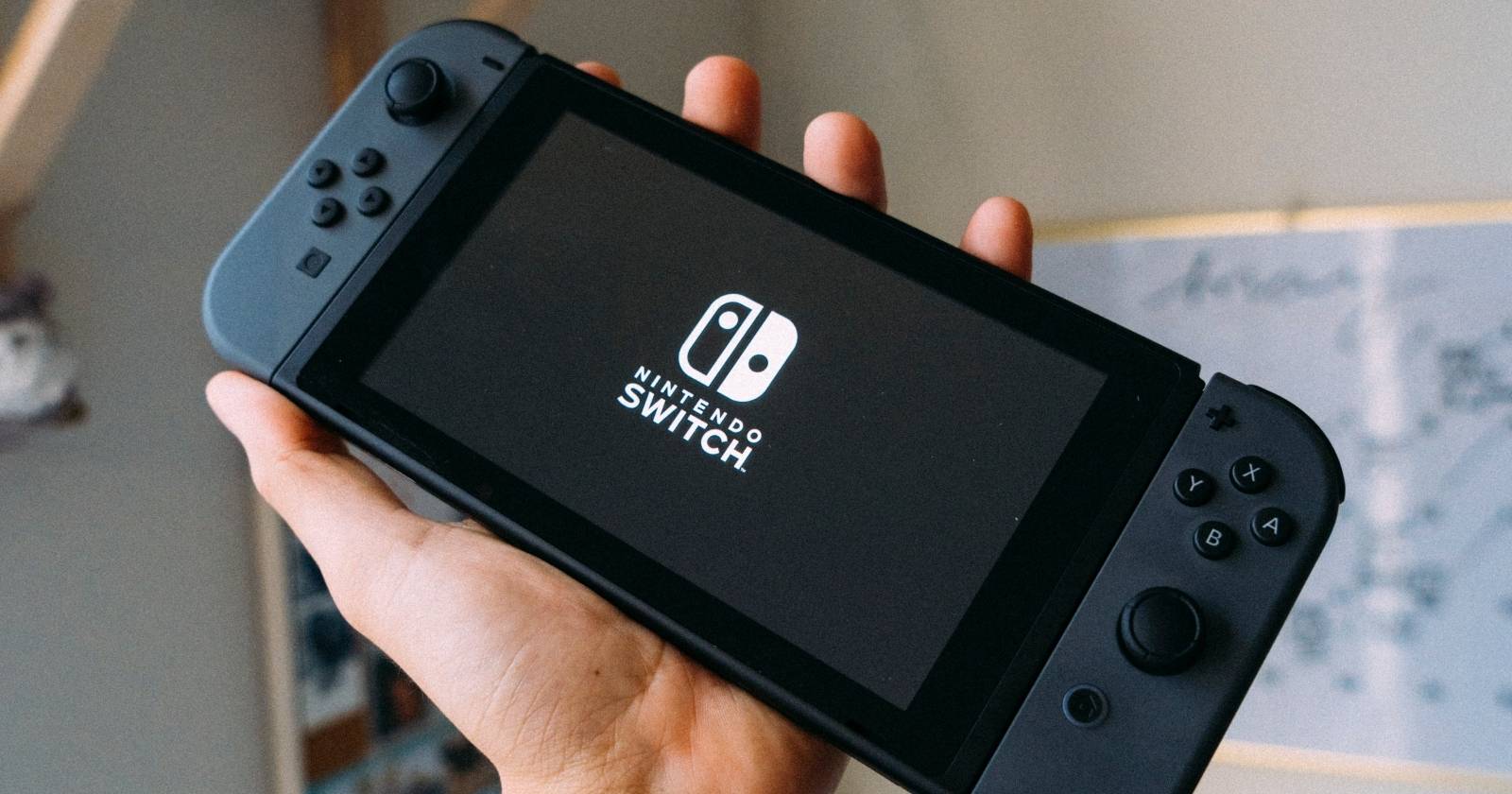 Серый Nintendo Switch, поднятый в руках