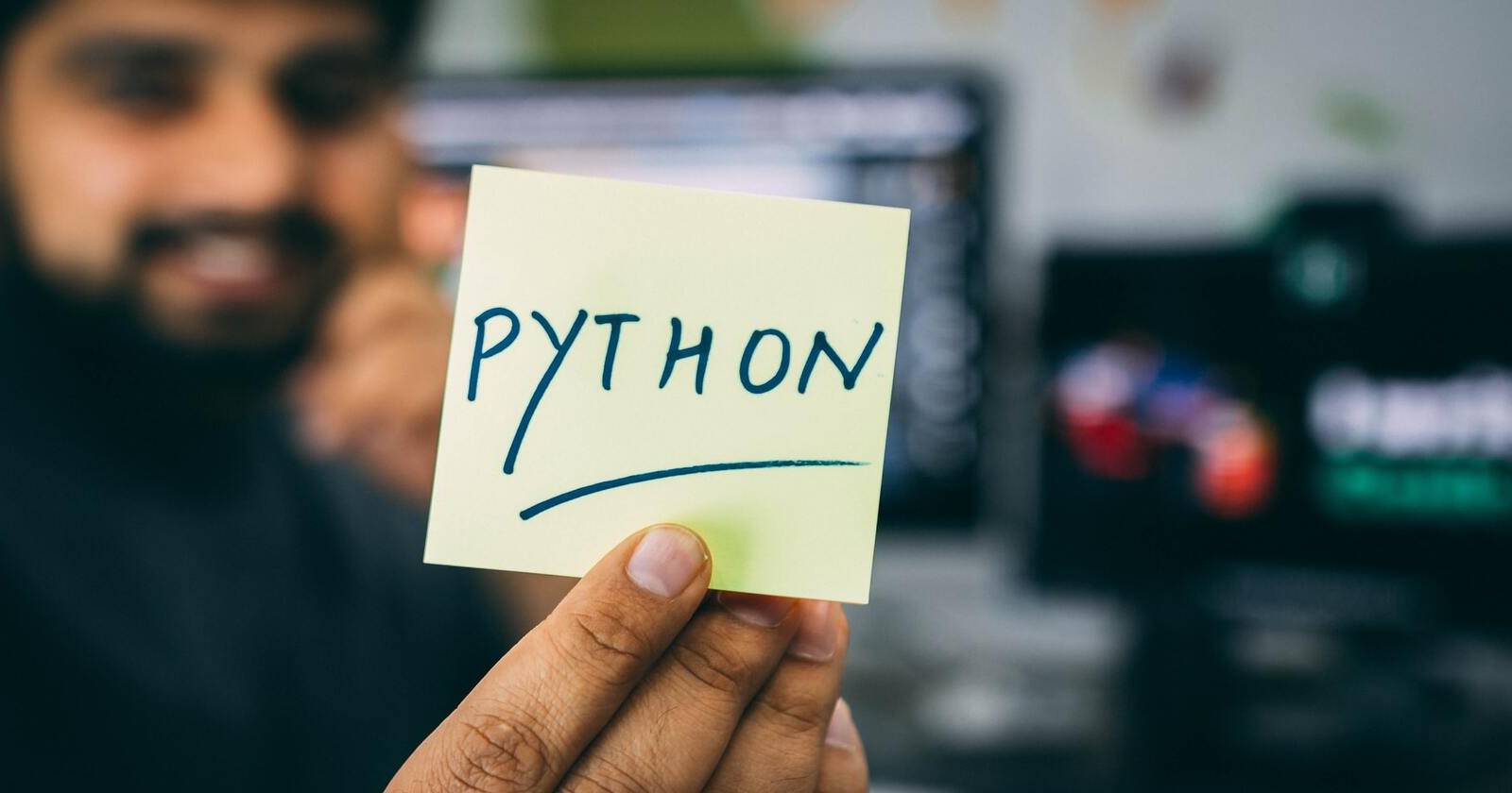 Мужчина держит карточку с логотипом Python