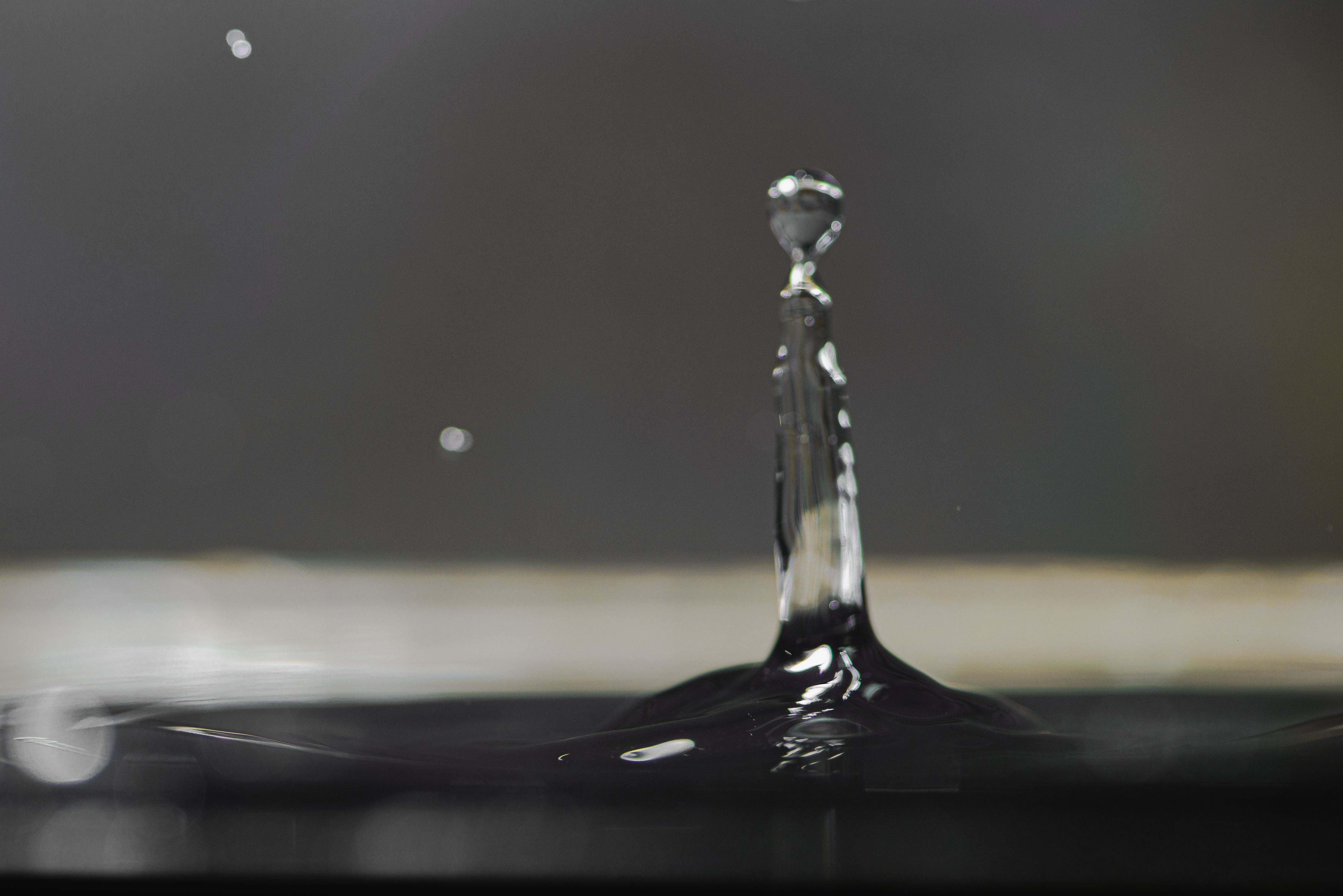 Размытая не в фокусе капля на черном фоне