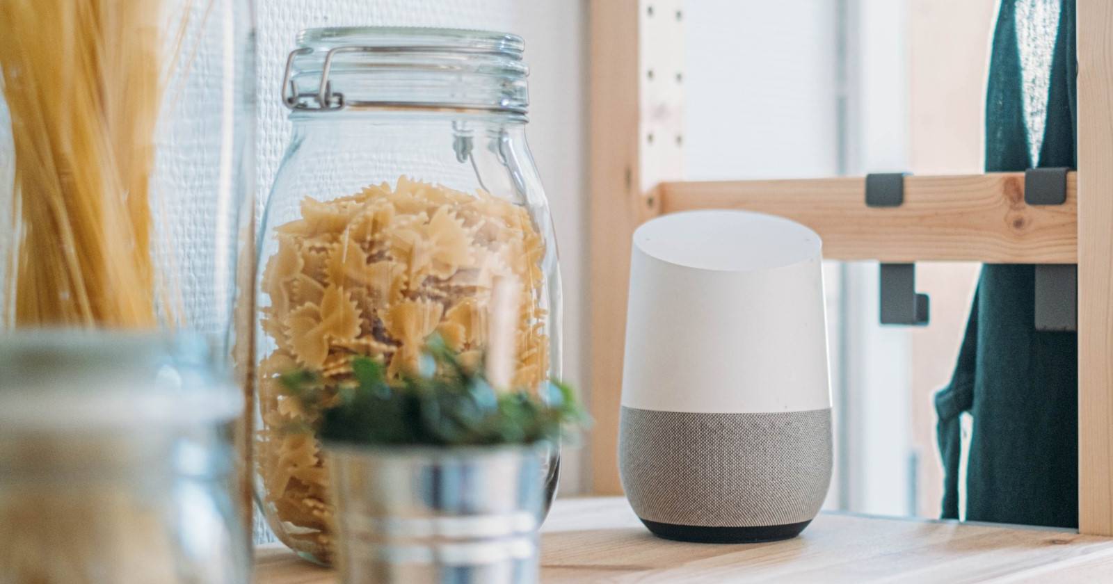 Устройство Google Home на кухонном столе рядом с пастой