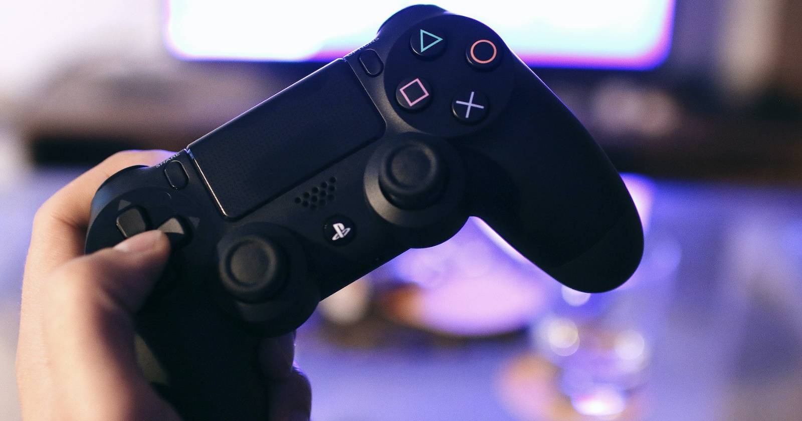 PS4-контроллер, удерживаемый за крестовину