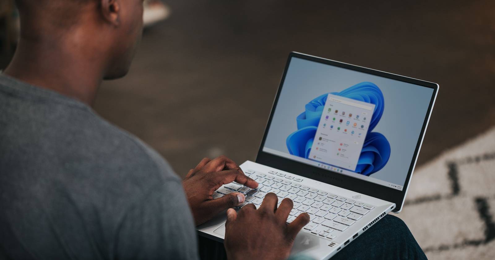 мужчина с ноутбуком под управлением Windows 11