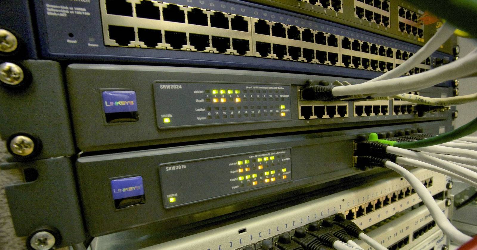 Стек сетевых коммутаторов с подключёнными Ethernet-кабелями