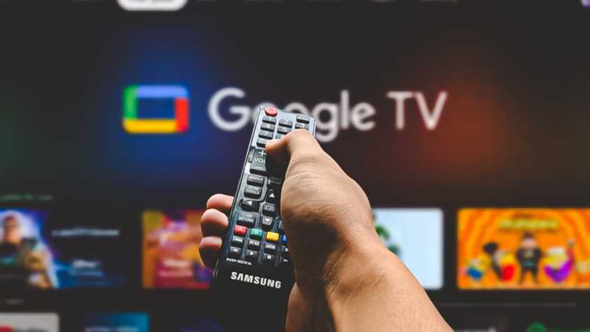 мужчина наводит пульт на телевизор с Google TV