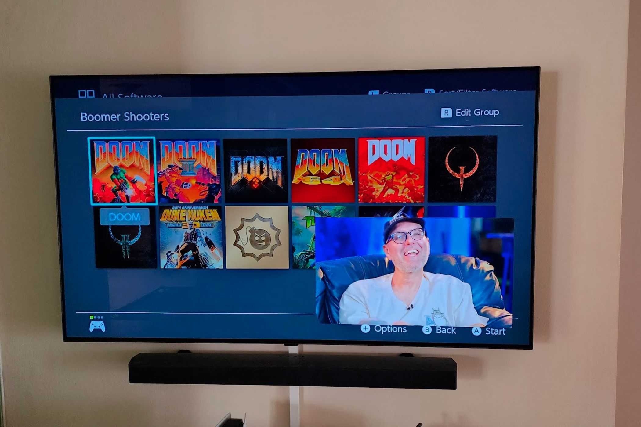Телевизор показывает меню Nintendo Switch как основной экран и видео с YouTube в правом нижнем углу.