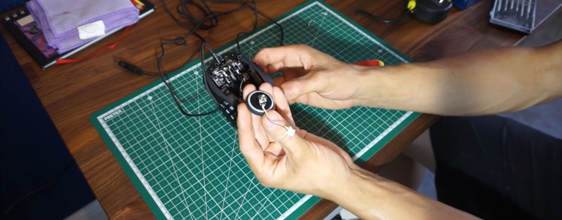 Человек демонтирует колесико мыши