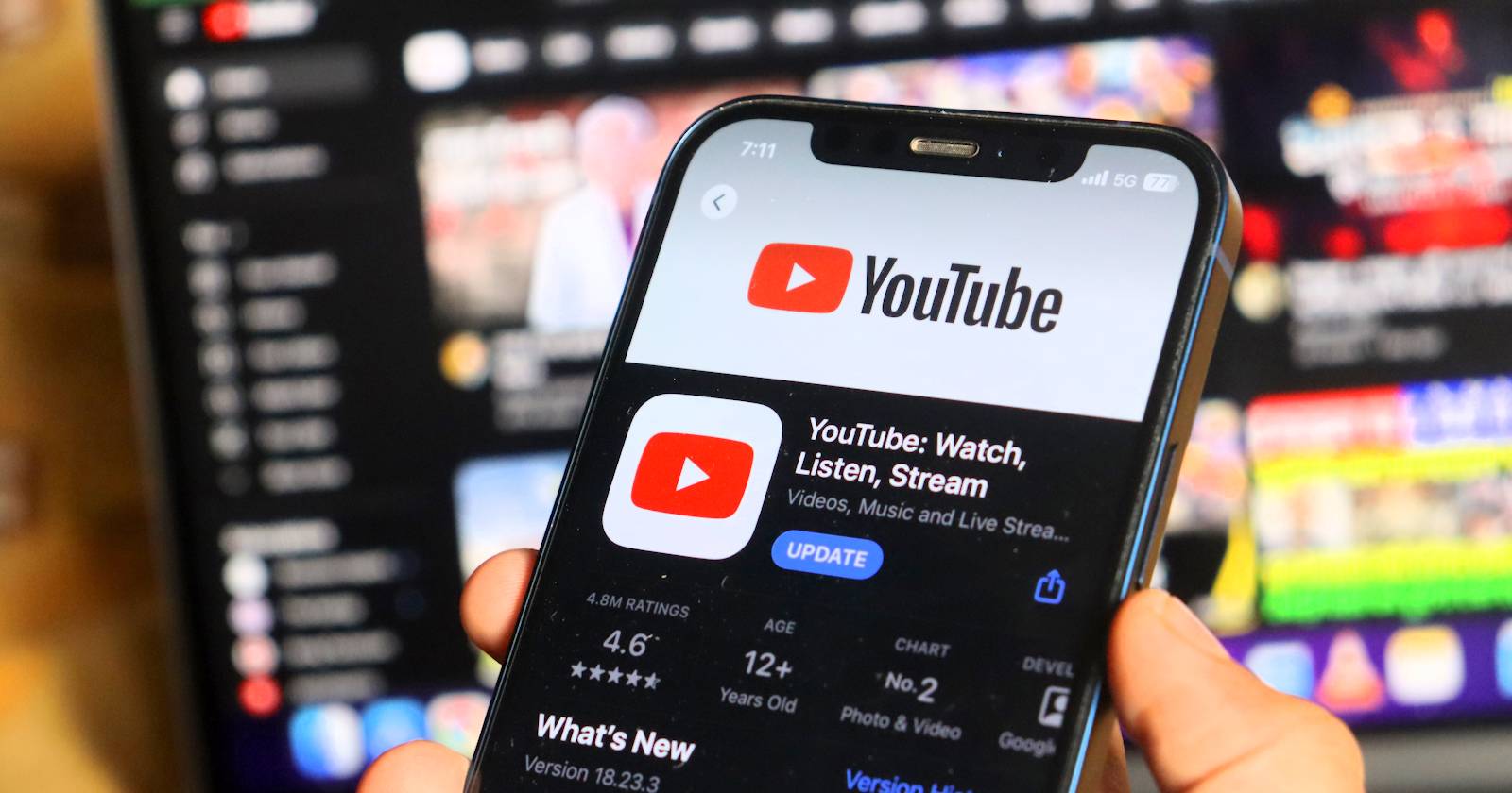 Человек смотрит логотип YouTube на экране смартфона