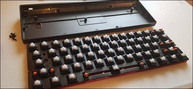 Разобранный корпус клавиатуры с видимыми винтами и платой