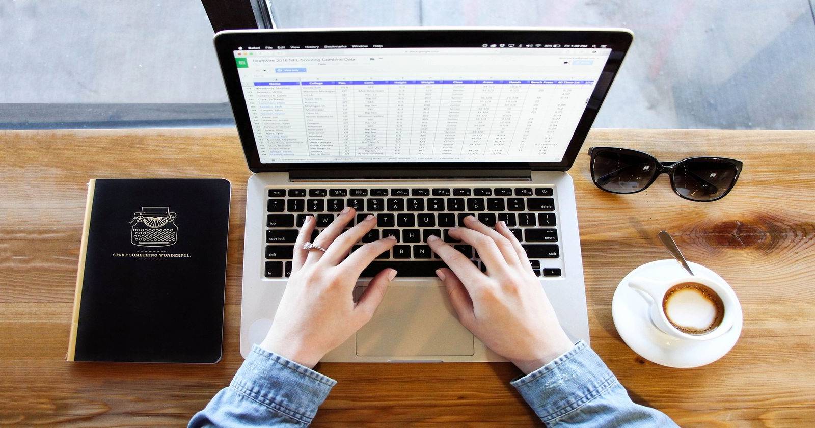 Человек печатает на MacBook; на экране открыт Excel с таблицей