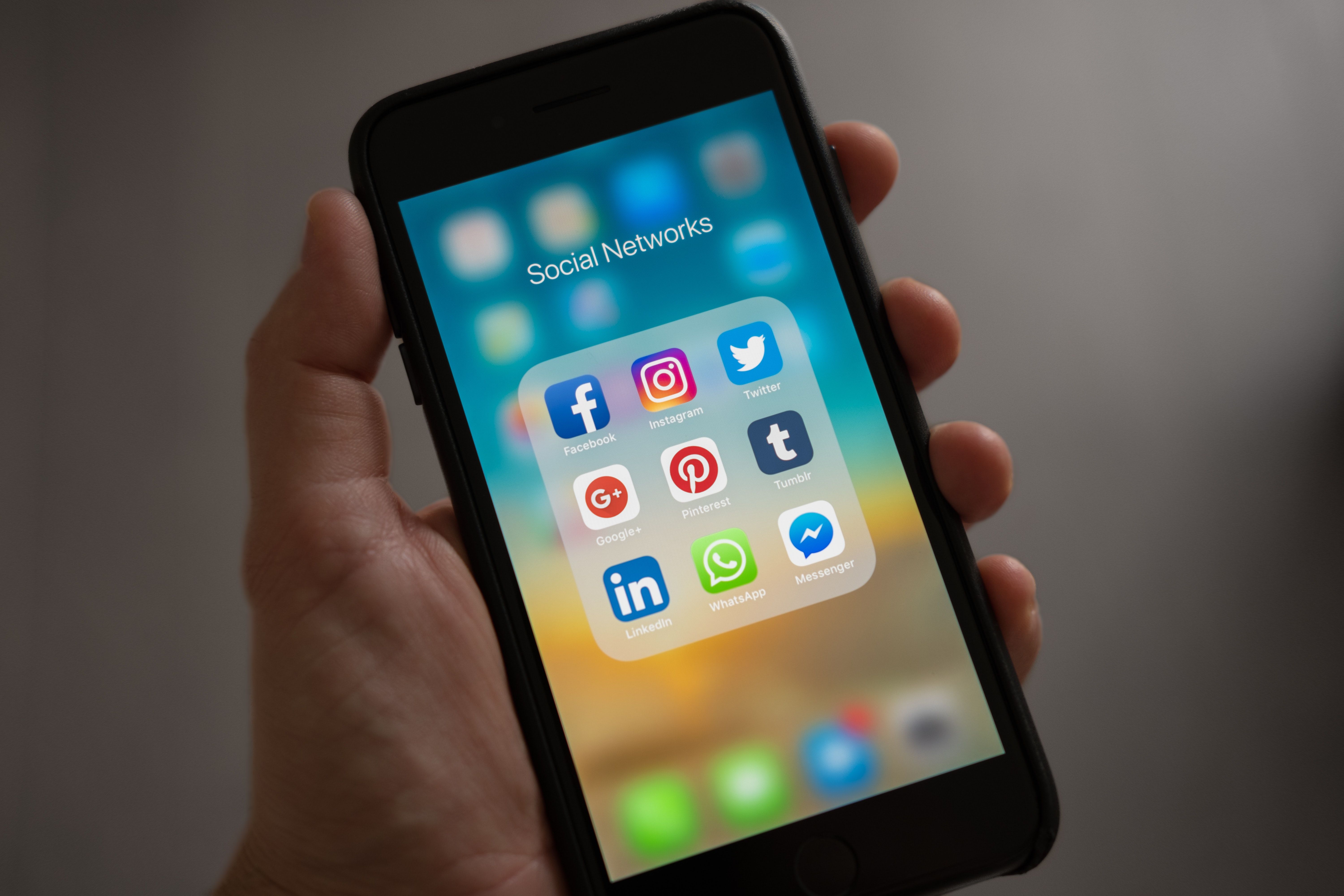 iPhone с папкой социальных сетей на домашнем экране