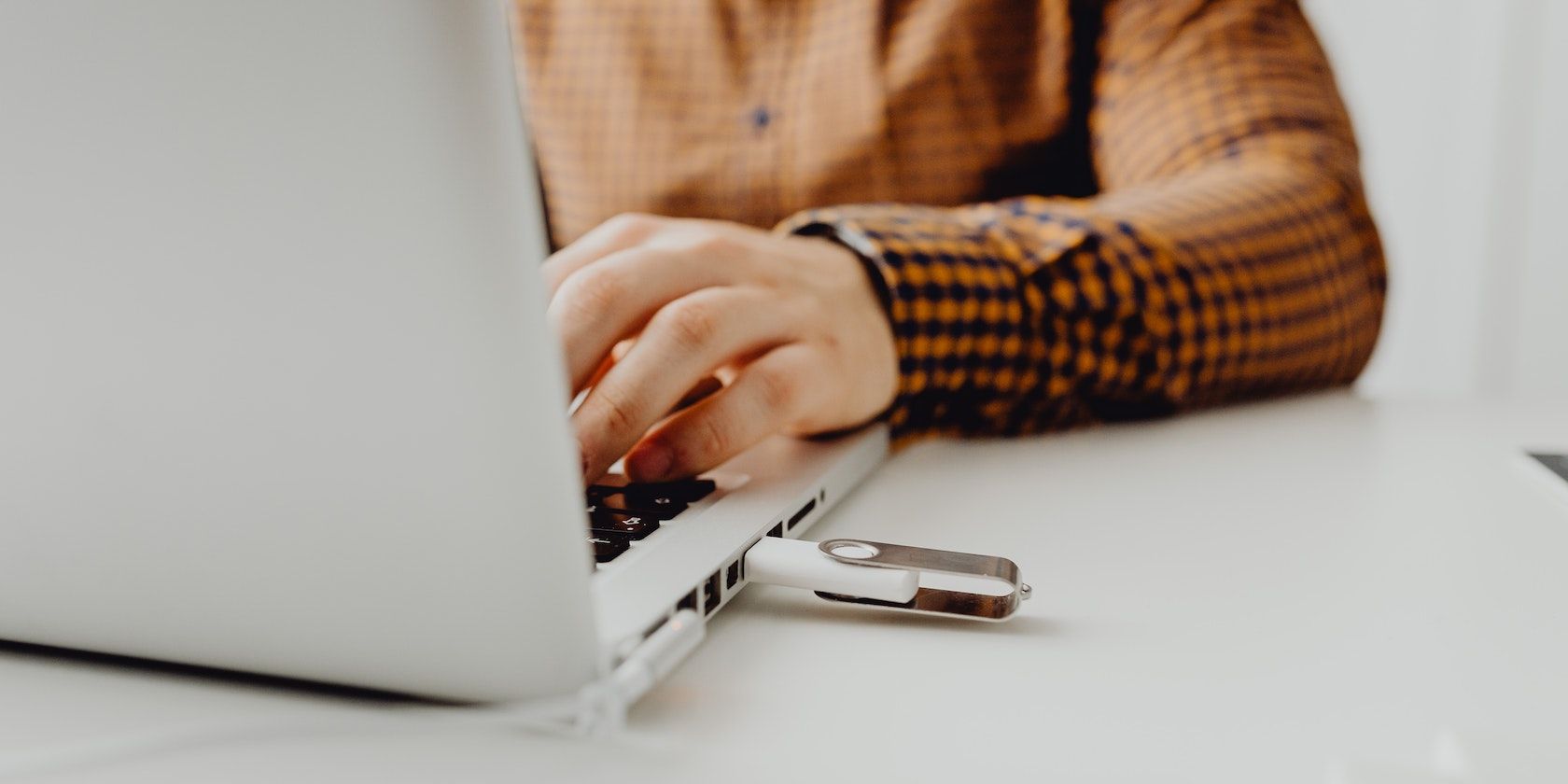 человек использует ноутбук с подключённой USB-флешкой