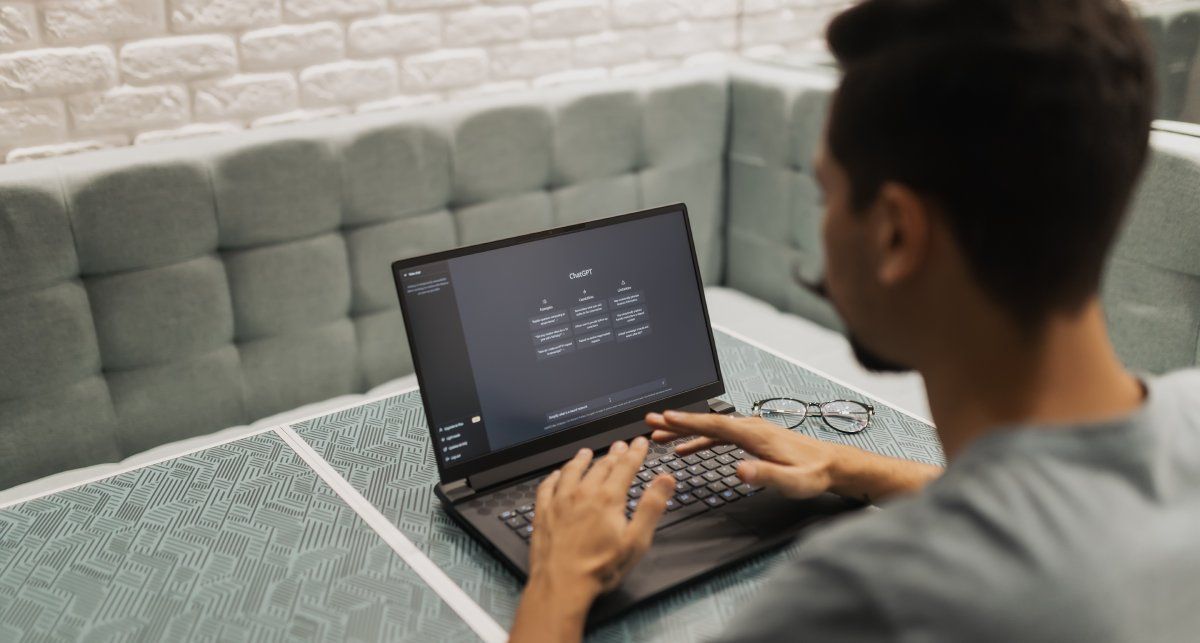 Мужчина за ноутбуком с открытым ChatGPT