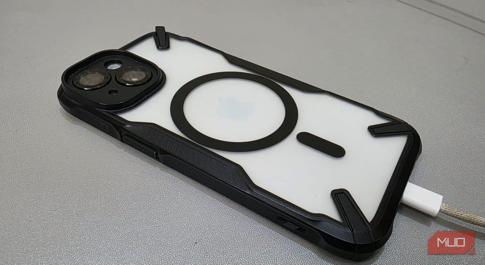 A charging cable is attached to the iPhone 15