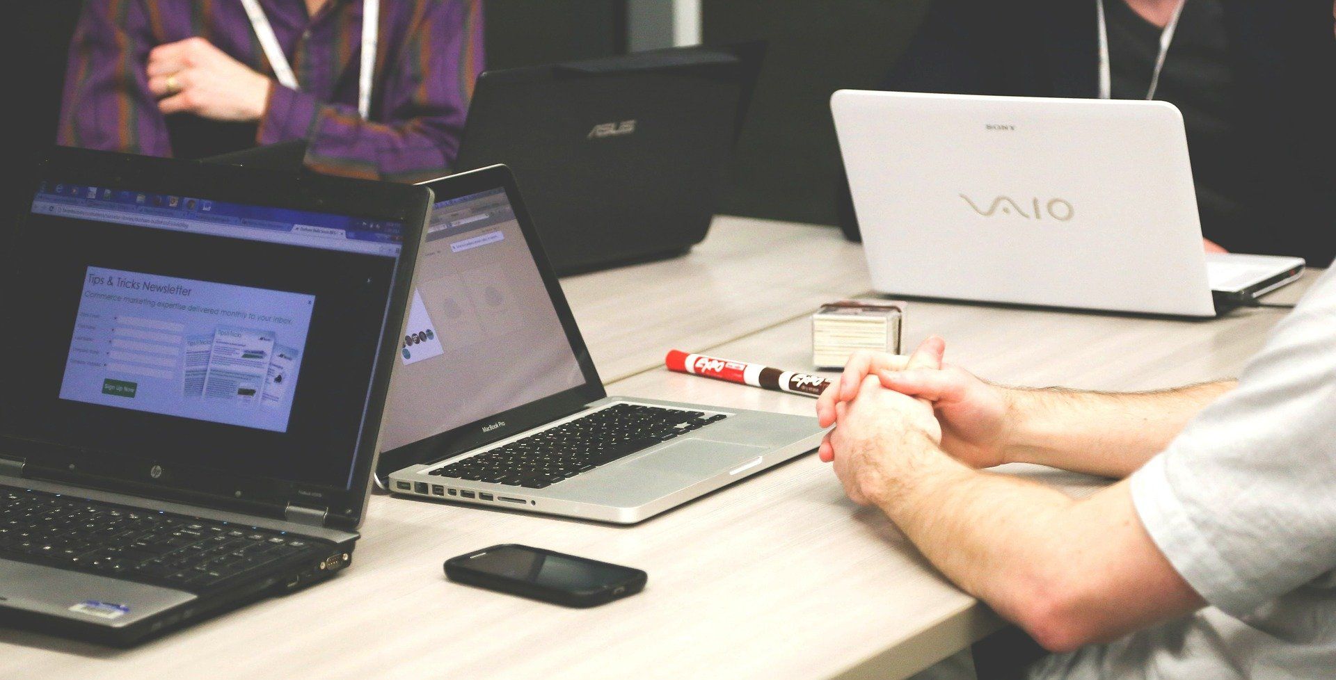 несколько человек одновременно работают за ноутбуками и смартфонами