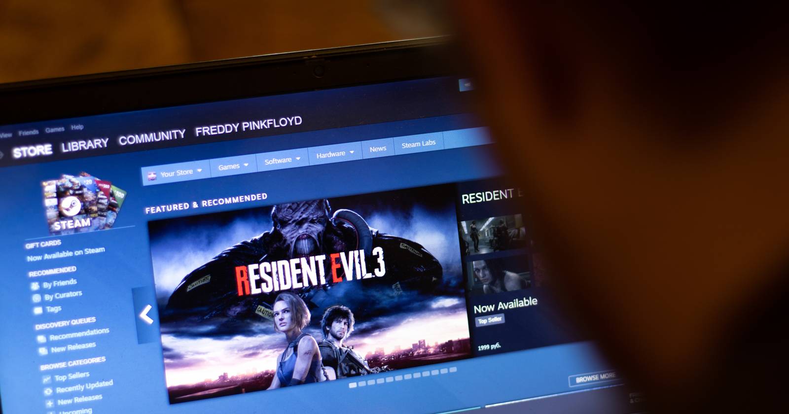 человек, смотрящий на Steam-клиент на ноутбуке
