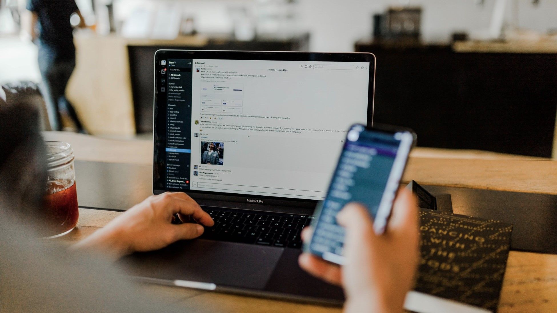 Человек использует телефон и ноутбук.