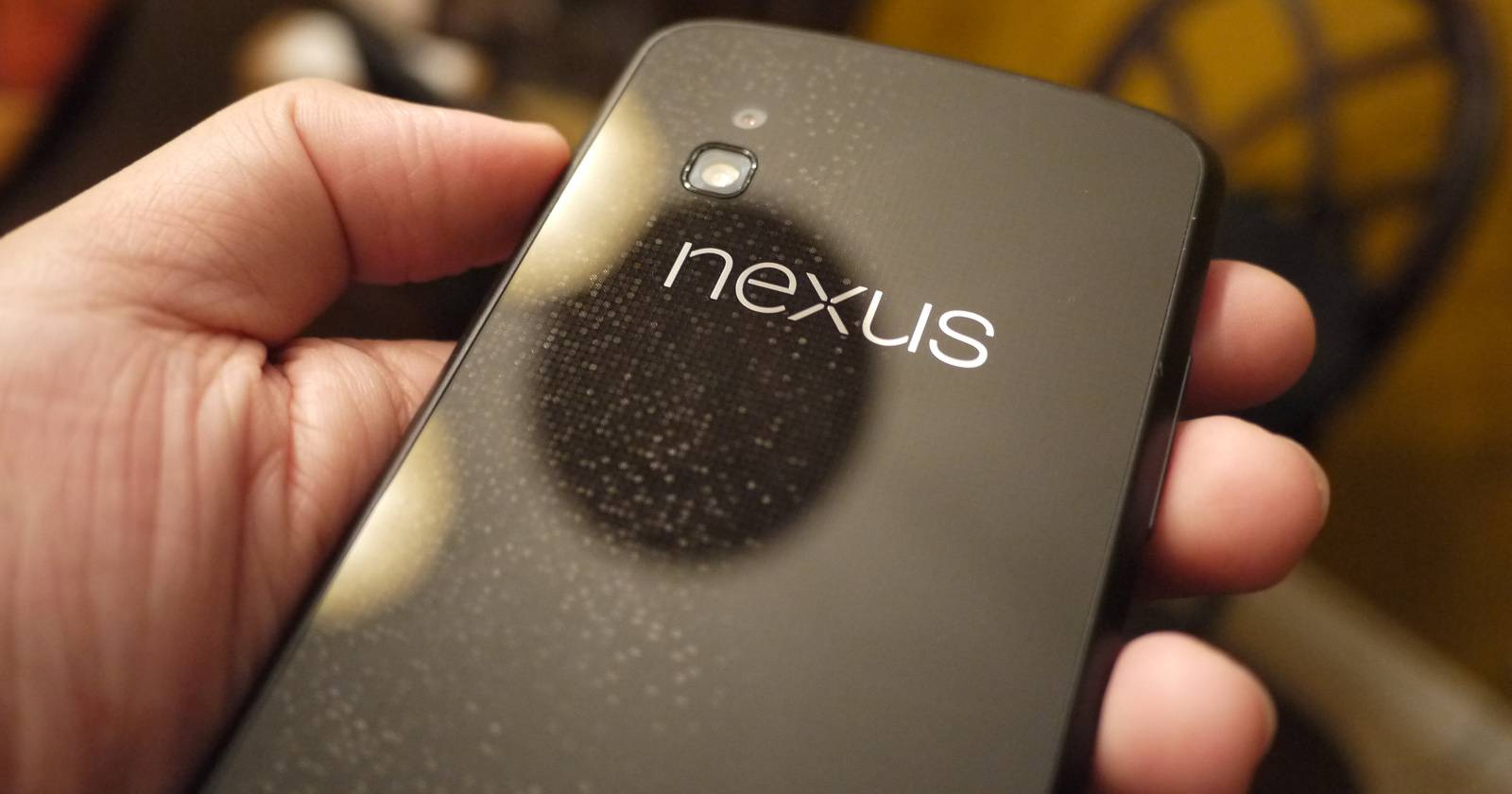 Фото Nexus-устройства в руках на рабочем столе