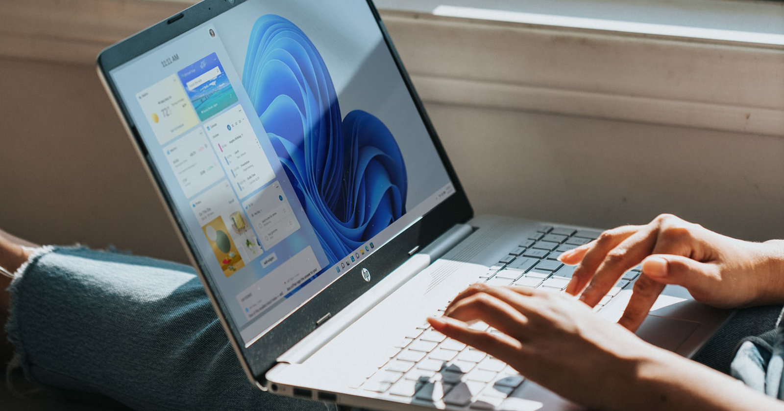 Руки пользователя, работающего на ноутбуке с Windows 11