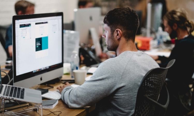 Человек за офисным столом с компьютером