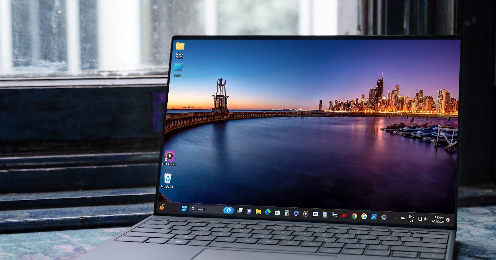 Ноутбук с Windows 11 и обоями с видом на городской пейзаж