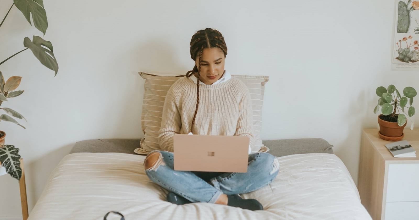 Женщина использует ПК с Windows, сидя на кровати