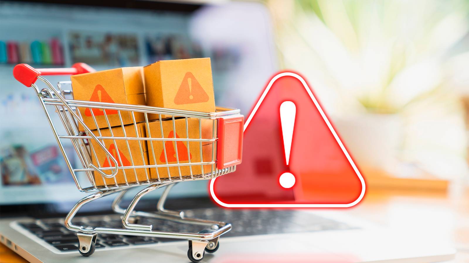 Ноутбук с корзиной для покупок и предупреждающим знаком, символизирующие онлайн-покупки и риск мошенничества.
