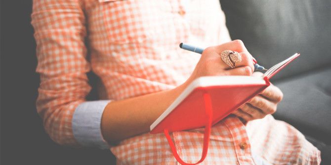 Открытый блокнот с записями и ручкой на столе